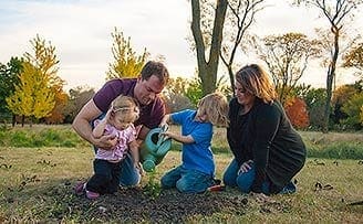 family watering new tree