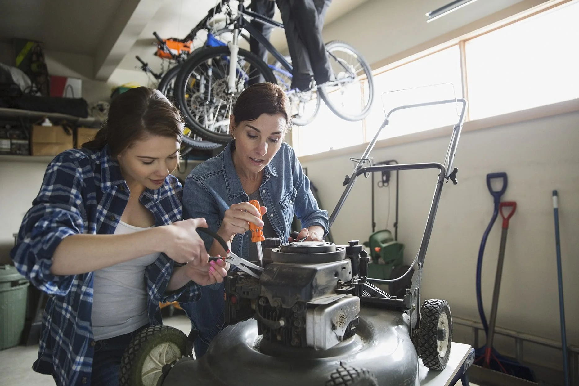 mother daughter fixing lawn mower